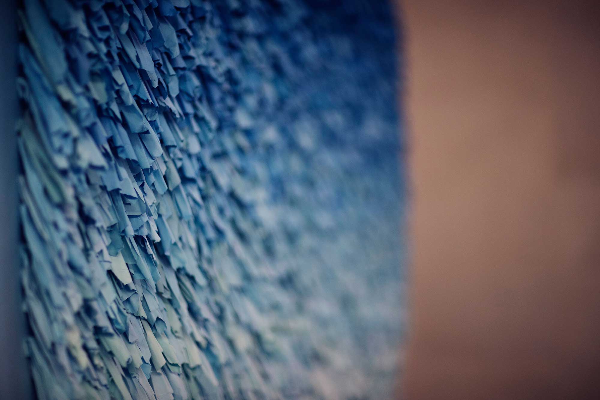A textured artwork features shades of blue from near-white to deep ocean blue
